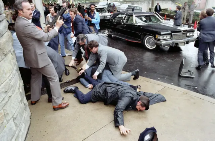 Secret Service agents rush President Reagan into his limousine after the assassination attempt, March 30, 1981